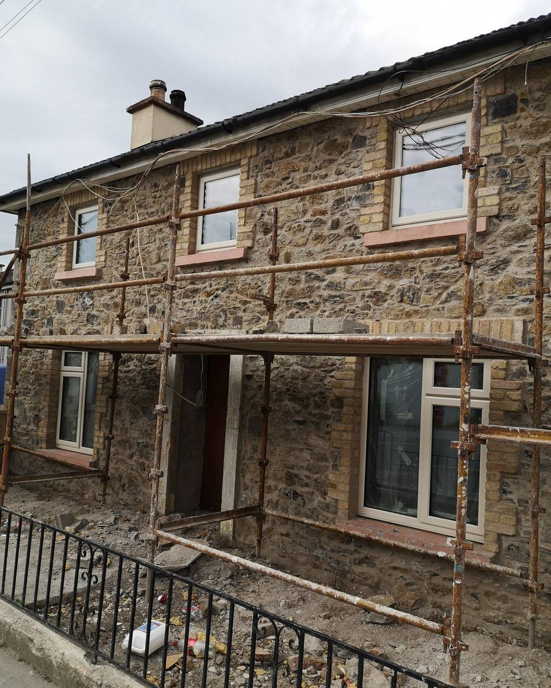 The stone cottage mid-renovation, wrapped in scaffolding.